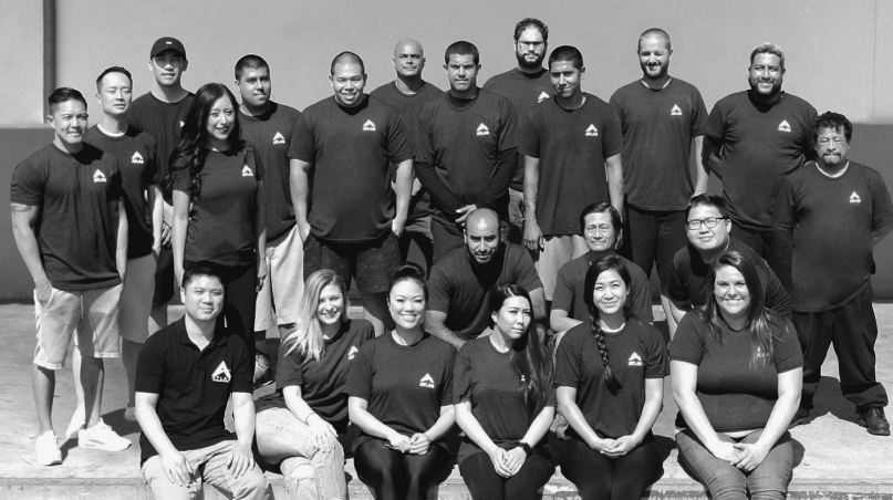 Group photo of the ARIEL Bath team wearing matching logo shirts, smiling and standing together in two rows.