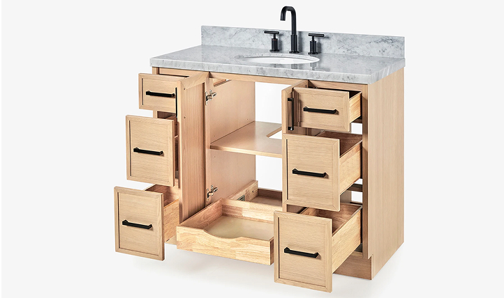 Fully opened oak vanity showing internal storage layout with drawers and compartments under marble countertop.