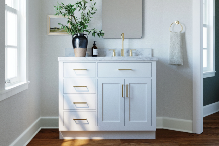 White single-sink vanity with gold hardware and marble top, placed in a corner bathroom with soft lighting.
